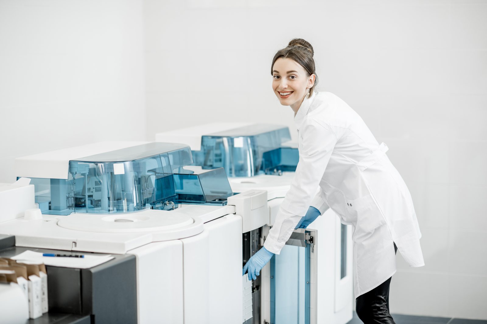 An SNT Biotech scientist operating a diagnostic analyzer